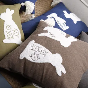 Detailed view of cute Easter bunny embroidered cushion cover with tassels, soft cotton linen material.
