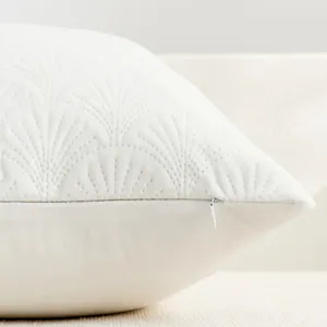 Detail shot of white velvet pillow cover featuring elegant quilted ginkgo leaf pattern.