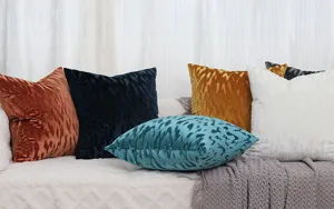 Vue détaillée de housses de coussin en velours nordique avec motif vagues sur canapé.