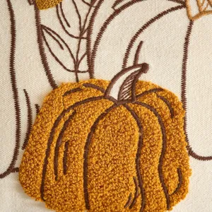 Vista dettagliata di una federa per cuscino ricamata con zucca autunnale per divano.