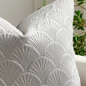 Close-up of light gray velvet pillow cover with exquisite embossed ginkgo leaf pattern.