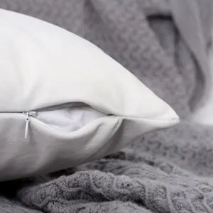 Macro detail of white velvet cushion cover zipper, featuring soft touch and fine textile texture.