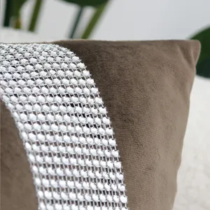 Close-up detail of luxury brown velvet cushion cover with sparkling rhinestone decorative band.