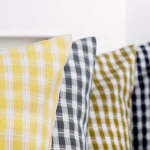 Fodera per cuscino in poliestere a quadri per divano di casa, dettaglio elegante.