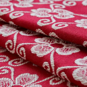 Detailed closeup of red and white jacquard fabric texture featuring delicate floral pattern.