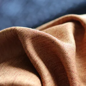 Close-up of autumn pumpkin orange woven cushion cover fabric, showing rich texture.
