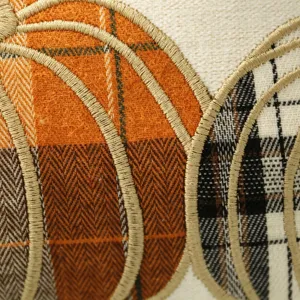 Dettaglio fodera cuscino zucca autunnale, ricamo tartan e spina di pesce per decorazioni.