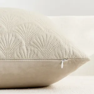 Close up of beige velvet pillow cover with quilted ginkgo leaf pattern and zipper.