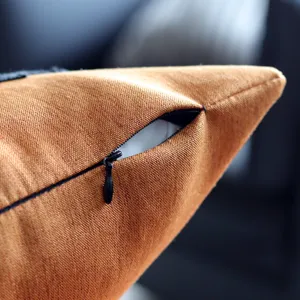 Orange textured pillow cover with hidden zipper detail, ideal for home living room decor.