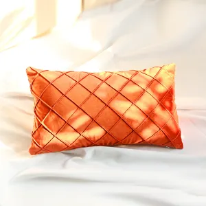 Close-up of luxury orange velvet decorative throw pillow with pleated diamond pattern