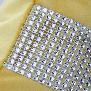 Close-up detail of yellow velvet cushion cover featuring sparkling silver rhinestone mesh design.