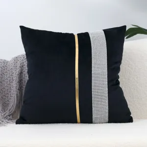 Black velvet cushion cover featuring rhinestone strip and gold accent, elegant home decor detail.