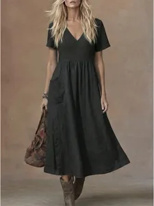 Casual black v-neck short sleeve pocket midi dress detailed view highlighting relaxed fit and side buttons.