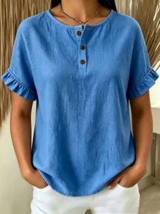 Detail view of blue linen short-sleeve top featuring ruffle cuffs and buttoned neckline.