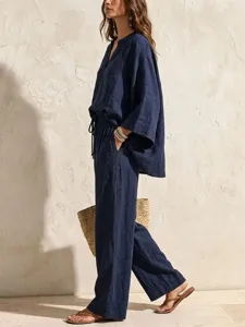 Detail view of a solid color linen two piece set featuring a V neck loose top and wide leg pants.
