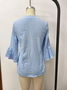 Detail view of light blue casual bell-sleeve blouse back design, soft fabric texture.