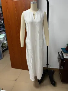 Detailed view of white sleeveless long dress with V-neck and pockets, casual relaxed fit.