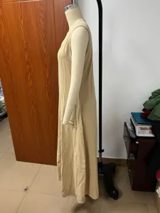 Side view detail of a casual beige sleeveless long dress showcasing the relaxed fit and pocket.