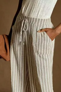 Close-up view of striped linen casual trousers, highlighting the drawstring waist and pockets.