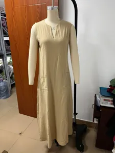 Detail view of casual sleeveless long dress in solid khaki with practical pockets.