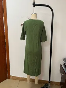 Back view detail of green linen midi dress showing ruffles sleeves on mannequin stand.