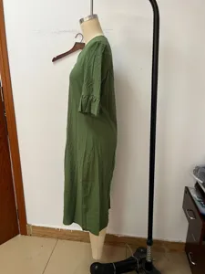 Green cotton linen dress detail view, elegant V-neck and ruffle sleeve design for women.