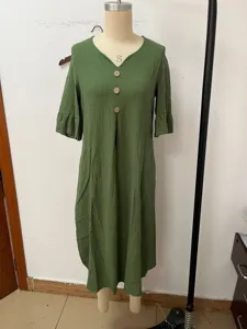 Green cotton linen dress detail showcasing V-neck design and big decorative buttons.
