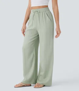 Detail shot of high-waist drawstring wide-leg casual linen pants in light green color.