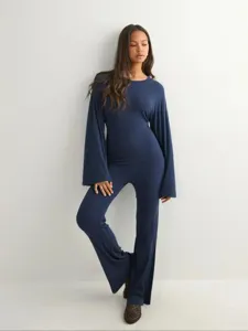Gedetailleerd overzicht van de elegante marineblauwe top met lange mouwen en broek.