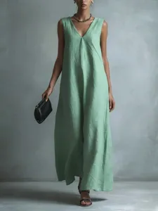 Detail view of a casual light green V-neck sleeveless long dress worn by a model.