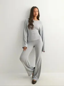 Detailopname van de casual herfstset met ronde hals en lange broek in lichtgrijze kleur.