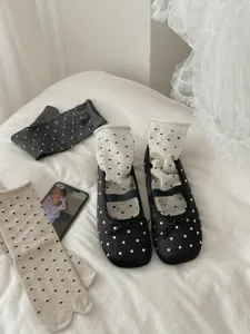 Detailed shot of stylish womens Mary Jane flat shoes paired with polka dot socks for summer.