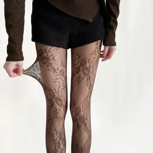 Detail view of retro floral lace fishnet tights, sexy hollow jacquard pantyhose for women.