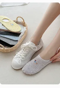 Detailed view of breathable mesh low cut boat socks with cute cartoon embroidery and shoes.