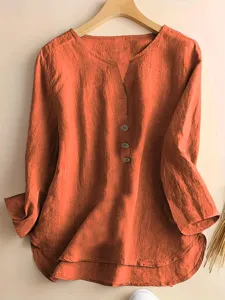 Detailed view of the casual orange long sleeve button blouse with notch collar and textured fabric.
