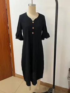 Black linen V-neck dress detail featuring large wooden buttons and stylish ruffle sleeves.