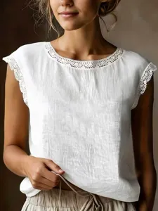 Close-up view of the white sleeveless linen top with delicate lace trim neckline details.