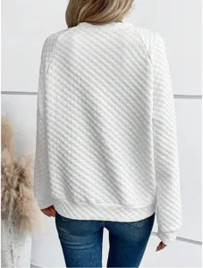 Detailed view of white quilted long sleeve sweatshirt back texture indoor scene lifestyle shot