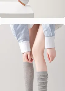Knit leg warmers detail featuring bow decor and hollow-out mesh, stylish hosiery for daily wear.