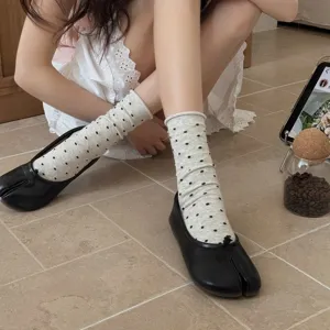 Women's cute polka dot mid-calf cotton socks paired with trendy split toe flats for summer.