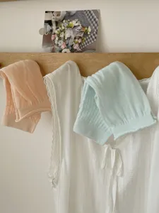 Detailed scene of breathable mesh stirrup socks in pastel colors hanging on a wooden rack.