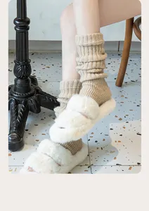 Close-up detail of cozy beige knit leg warmers paired with fluffy slippers for autumn and winter.