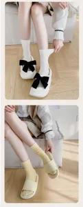 Detail view showing women solid mid tube socks paired with casual flat shoes in room scene.