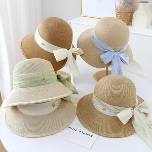 Details van de zomerse strohoed voor dames met elegante strik, ademende strandzonnehoed.