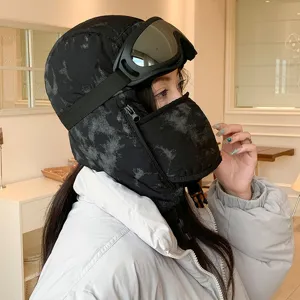 Detail shot of winter windproof trapper hat with goggles and mask, black camo design.