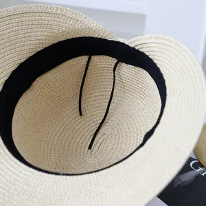 Detailed view of the straw hat interior showing fine woven texture, sweatband and wind rope.