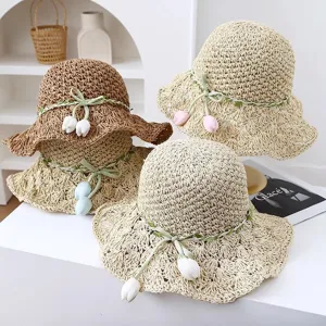 Detailed view of the sweet straw sun hat with cute tulip decorations for summer beach.