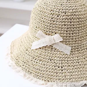 Primer plano detalle de sombrero de paja de mujer con lazo de encaje dulce para playa de verano.