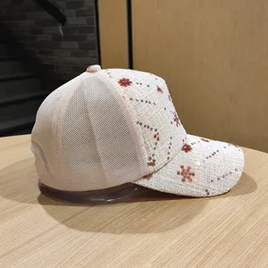 Dettaglio in primo piano del berretto da baseball in rete con paillettes beige, tessuto traspirante.