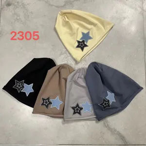 Détails du bonnet slouchy avec écussons étoiles, gros plan sur le tissu et les coutures.